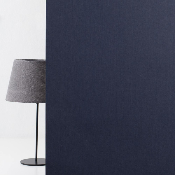 Dunkelblauer Stoff mit feiner Textur wird als Hintergrund verwendet. Die gleichmäßige Struktur bietet eine ansprechende visuelle Basis für Inhalte. Der Stoff hat eine matte Oberfläche ohne Muster.
