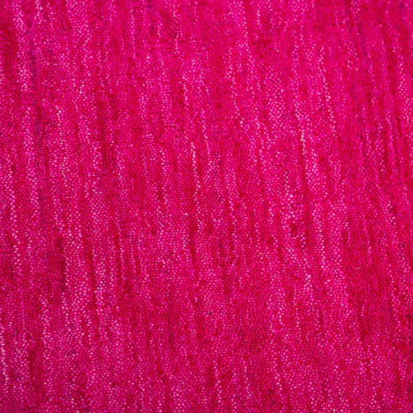 Hochformatiger, samtig-weicher Wollteppich in kräftigem Pink. Der Teppich zeigt eine gleichmäßige Struktur und ist für die Wohnraumgestaltung geeignet.