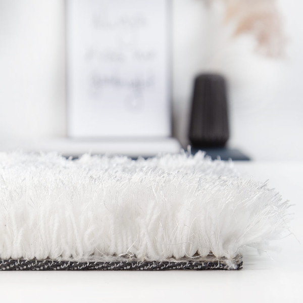 Kuschelweicher Hochflorteppich in Weiß mit flauschigem Material. Der Teppich bietet eine hohe Gemütlichkeit und eignet sich zur individuellen Gestaltung. Maße sind nach Kundenwunsch anpassbar.