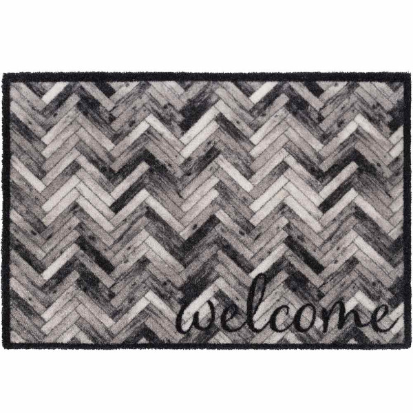 Schwarze und graue Fußmatte im Zickzackmuster mit dem Wort 