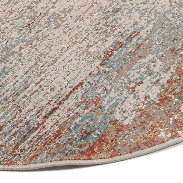 Runder Teppich in creme mit bunten Akzenten. Der Teppich hat ein modernes Design und zeigt eine zentrale, helle Fläche, die von Farbschattierungen umgeben ist.