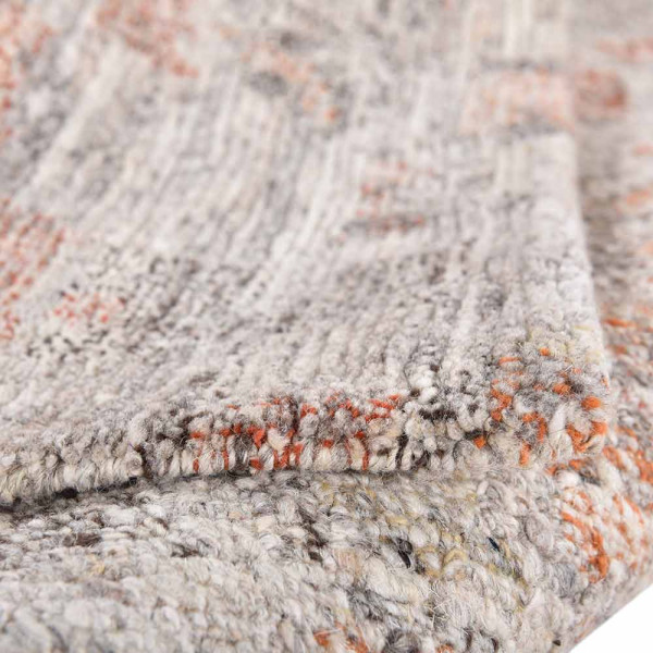 Farbenfroher Teppich Lhasa aus tibetanischer Schurwolle in verschiedenen Farben mit einer strukturierten Oberfläche. Er wird als dekoratives Element für Räume angeboten.