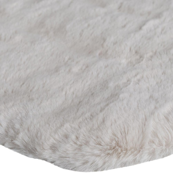 Flauschiger Teppich in Elfenbeinfarbe mit einer Größe von 55 cm x 160 cm liegt flach. Die Form des Teppichs ist geschwungen und einladend.