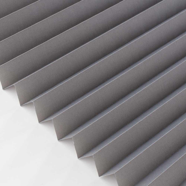 Graues, halbtransparentes Plissee mit mehreren Falten. Es wird für Sicht- und Sonnenschutz genutzt und bietet eine elegante, funktionale Gestaltungsmöglichkeit für Fenster.