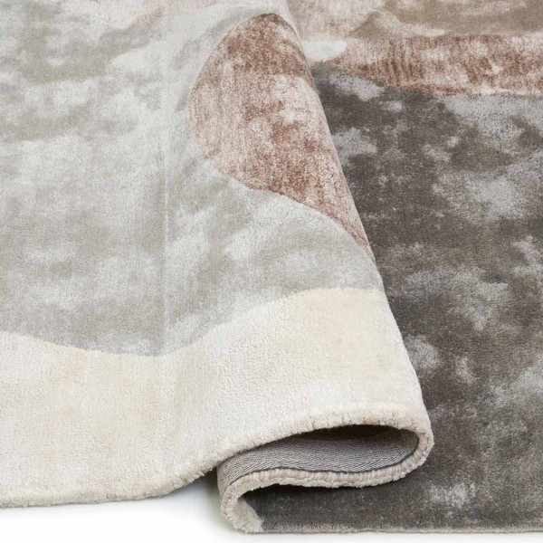 Moderner Teppich in Beige mit abgerundeten, organischen Formen in Grau, Braun und Beige. Der Teppich trägt den Namen Lagos und ist auf einem hellen Untergrund positioniert.