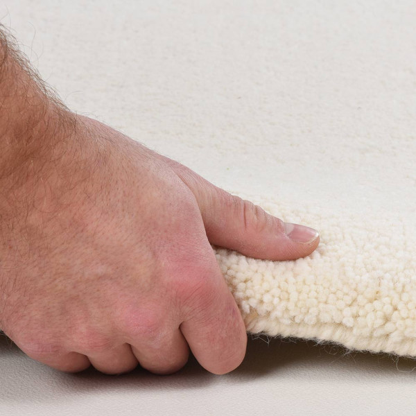 Beiger, flacher Teppich im minimalistischen Design, liegt auf einem neutralen Untergrund. Er präsentiert sich in einem klaren, einheitlichen Farbton ohne Muster oder Verzierungen.