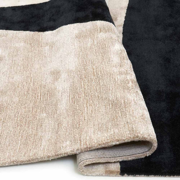 Moderner Kurzflorteppich Jazz in beige mit aufregendem Design. Der Teppich hat abstrakte Muster in Schwarz und Beige, die miteinander harmonieren und Eleganz ausstrahlen.