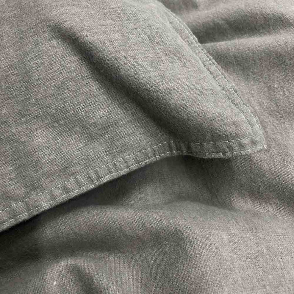 Flanell-Bettwäsche in Grauton mit einem Kopfkissen und einer Decke. An der Decke ist eine Detailansicht des Reißverschlusses sichtbar. Ideal für gemütliche Nächte.