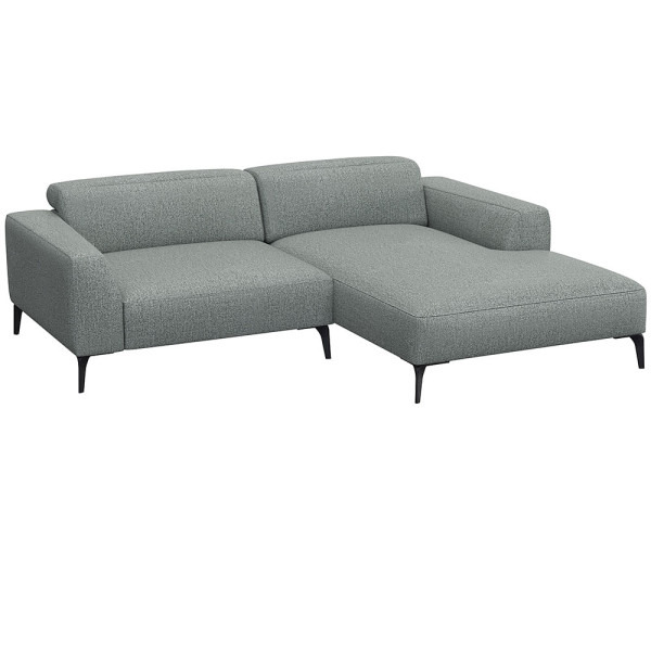 Beige Chaiselongue-Sofa mit klaren Linien und niedrigem Rücken, bestehend aus strapazierfähigem Material. Es bietet eine geräumige Liegefläche und elegante, schwarze Beine.