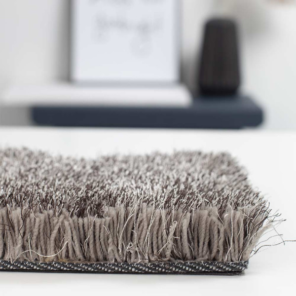 Hochflor-Teppich Lago Mix in dunkelgrau. Der Teppich zeigt eine weiche, strukturierte Oberfläche und ist an einer Kante sichtbar, um die Qualität des Materials zu betonen.