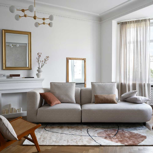 Multicolor Teppich mit grafischem Design. Er zeigt verschiedene geometrische Formen in Grau, Braun und Beige. Die Farben und Strukturen verleihen dem Teppich einen modernen Look.