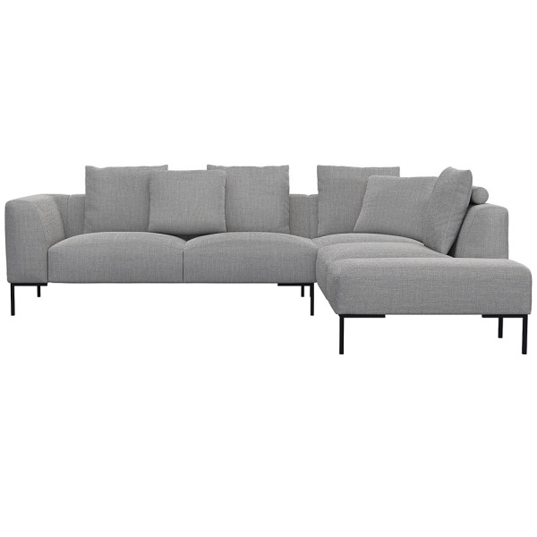 Helles, modernes Ecksofa SAVA mit offenem Ende. Das Sofa besitzt mehrere bequeme Kissen und steht auf schwarzen Metallbeinen. Es eignet sich ideal für stilvolle Wohnräume.