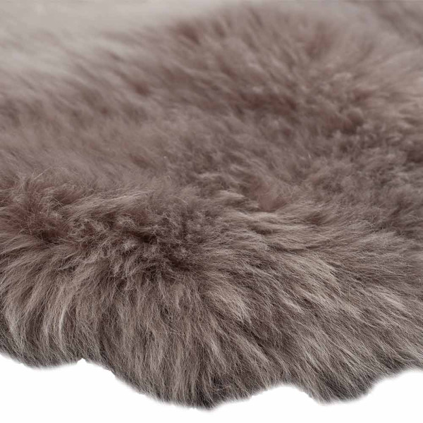 Doppeltes Lammfell in der Farbe Natur liegt flach auf einer Oberfläche. Die Oberfläche ist weich und pelzig, mit einer länglichen Form von 50 x 160 cm.