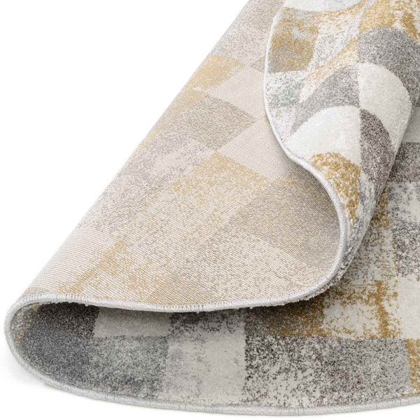 Runder Hochflor-Teppich mit großem Karo-Muster in Grau und Creme. Der Teppich hat flauschige Texturen und ist ideal für Wohnräume. Maße variieren zwischen 65 x 130 cm und 240 cm Durchmesser.