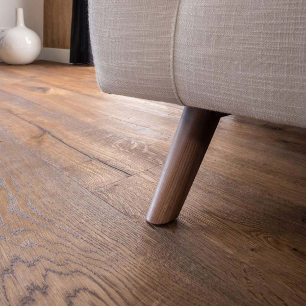 Dunkles Parkett aus Eiche, mit einer strukturierten Oberfläche, liegt verlegt auf dem Boden. Es zeigt verschiedene Farbtöne und Maserungen, die dem Holz einen rustikalen Charakter verleihen.