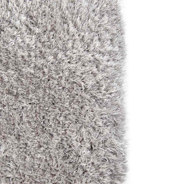 Hochfloriger, kuscheliger Teppich in Hellgrau liegt auf einem glatten Untergrund. Die Teppichkanten sind weich und zeigen ein flauschiges, einheitliches Texturmuster.