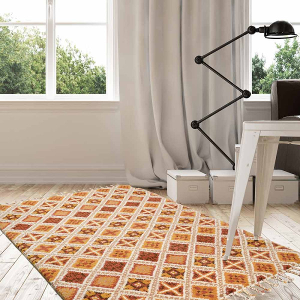 Terracottafarbener Teppich mit geometrischem Muster in gelb, rot und grün. Der Teppich hat Fransen an der Oberkante und misst 170 x 240 cm.