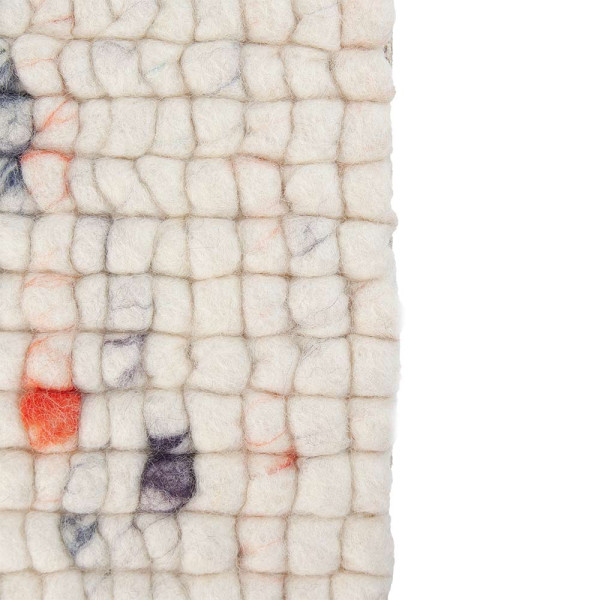 Weißer Webteppich mit bunten, farbigen Punkten in unterschiedlichen Größen. Der Teppich liegt flach auf einem hellen Untergrund und zeigt eine strukturierte Oberfläche aus Schurwolle.