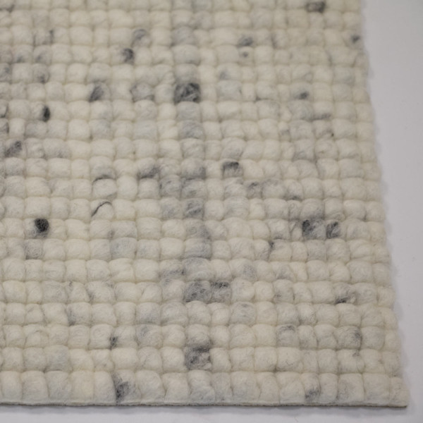 Heller, nachhaltiger Webteppich aus Schurwolle mit einer strukturierten, gepunkteten Oberfläche in Weiß und Grau. Der Teppich eignet sich zur individuellen Gestaltung nach Maß.