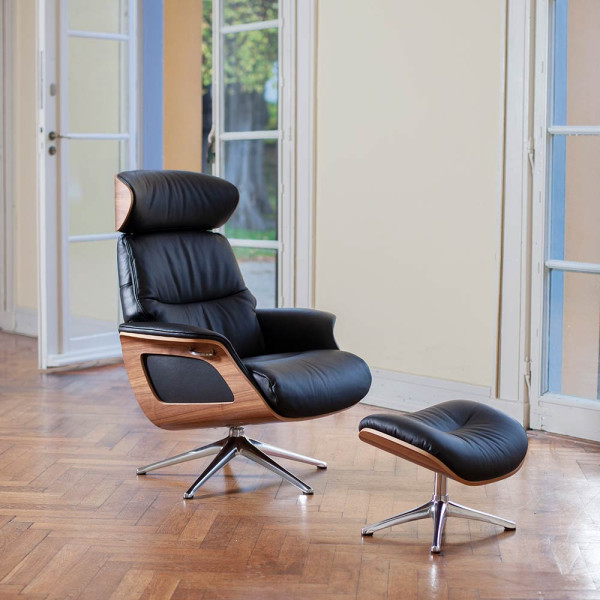 Relaxsessel Clement hat einen Holz-Korpus und ist mit einem grauen Polster ausgestattet. Der Sessel bietet komfortable Sitzmöglichkeiten und ist drehbar. Der Preis liegt bei 1.399,00 €.