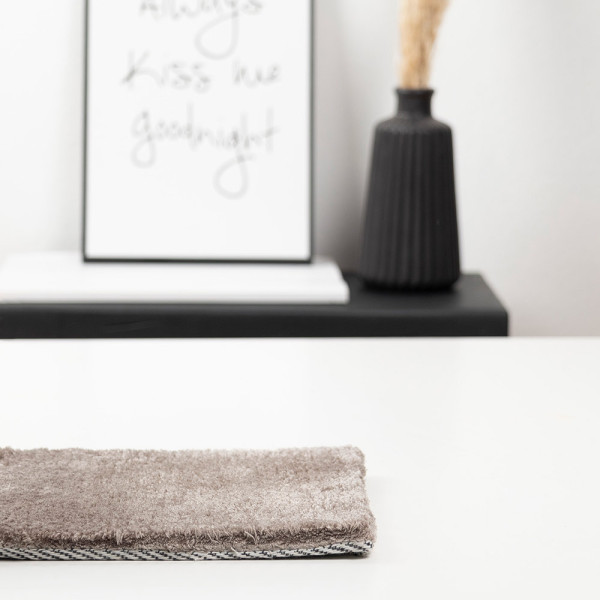 Brauner Kurzflor-Webteppich in Taupe mit einer strukturierten Oberfläche. Der Teppich ist maßgefertigt und bietet eine moderne Optik für verschiedene Wohnräume.