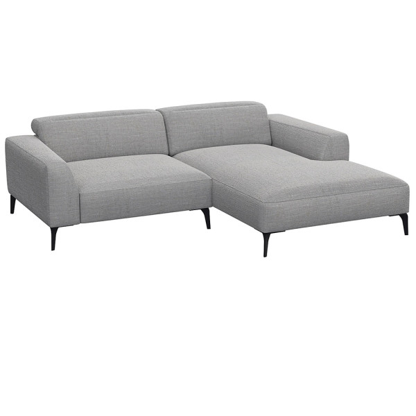 Beige Chaiselongue-Sofa mit klaren Linien und niedrigem Rücken, bestehend aus strapazierfähigem Material. Es bietet eine geräumige Liegefläche und elegante, schwarze Beine.