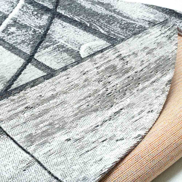 Grau-musteriger Teppich mit unterschiedlichen Holzstrukturen und Linien. Der Teppich hat einen kreisförmigen Schnitt und zeigt eine beruhigende, elegante Textur.