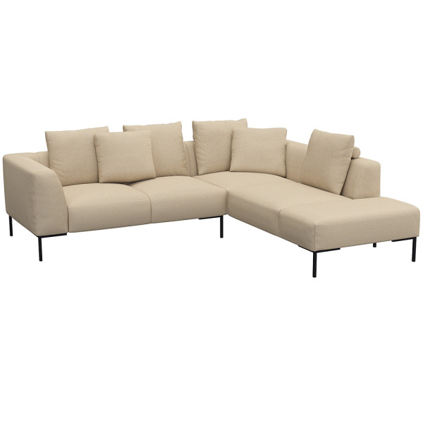 Helles, modernes Ecksofa SAVA mit offenem Ende. Das Sofa besitzt mehrere bequeme Kissen und steht auf schwarzen Metallbeinen. Es eignet sich ideal für stilvolle Wohnräume.