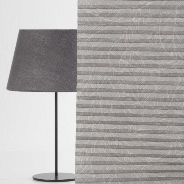 Graues Wabenplissee mit strukturiertem Muster liegt flach angeordnet. Das Produkt eignet sich für maßgeschneiderte Sonnenschutzlösungen und bietet sowohl Sichtschutz als auch Wärmeregulierung.