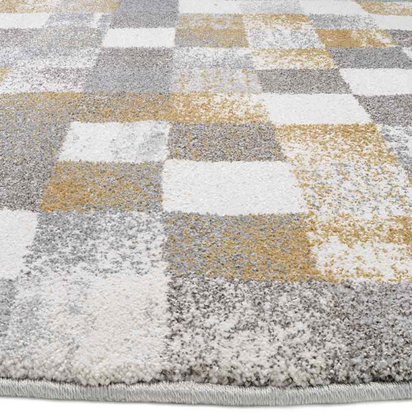 Runder Hochflor-Teppich mit großem Karo-Muster in Grau und Creme. Der Teppich hat flauschige Texturen und ist ideal für Wohnräume. Maße variieren zwischen 65 x 130 cm und 240 cm Durchmesser.