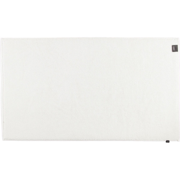 Weißer Badteppich 1007 von Cawö liegt flach auf dem Boden. Er hat eine rechtwinklige Form und eine weiche Textur. Die Maße sind 60 x 100 cm.