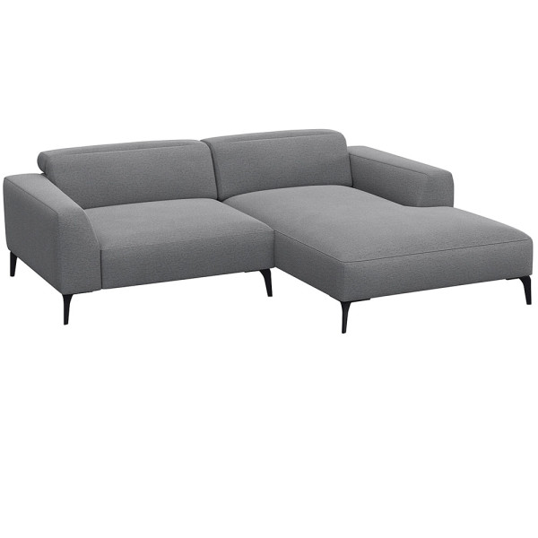 Beige Chaiselongue-Sofa mit klaren Linien und niedrigem Rücken, bestehend aus strapazierfähigem Material. Es bietet eine geräumige Liegefläche und elegante, schwarze Beine.