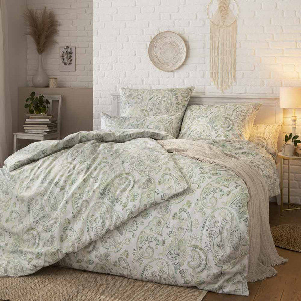 Estella Bettwäsche Yura 7541 aus Mako-Satin mit floralem Muster liegt ordentlich auf dem Bett. Dazu gehören ein Bettbezug und zwei Kissenbezüge.