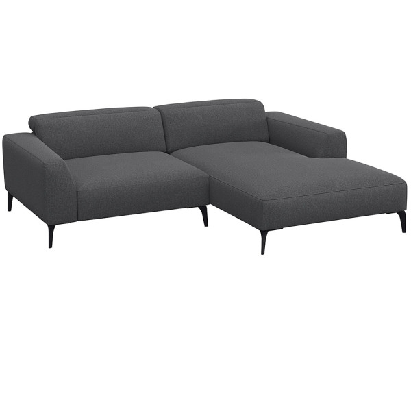 Beige Chaiselongue-Sofa mit klaren Linien und niedrigem Rücken, bestehend aus strapazierfähigem Material. Es bietet eine geräumige Liegefläche und elegante, schwarze Beine.