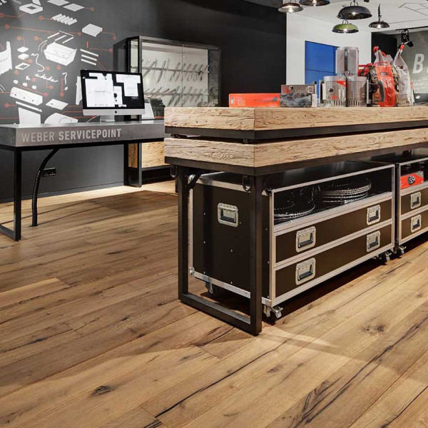 Dunkle und helle Holzstufen sind in verschiedenen Schattierungen angeordnet. Das Parkett zeigt natürliche Maserungen und Strukturen, die das altholzähnliche Design betonen.