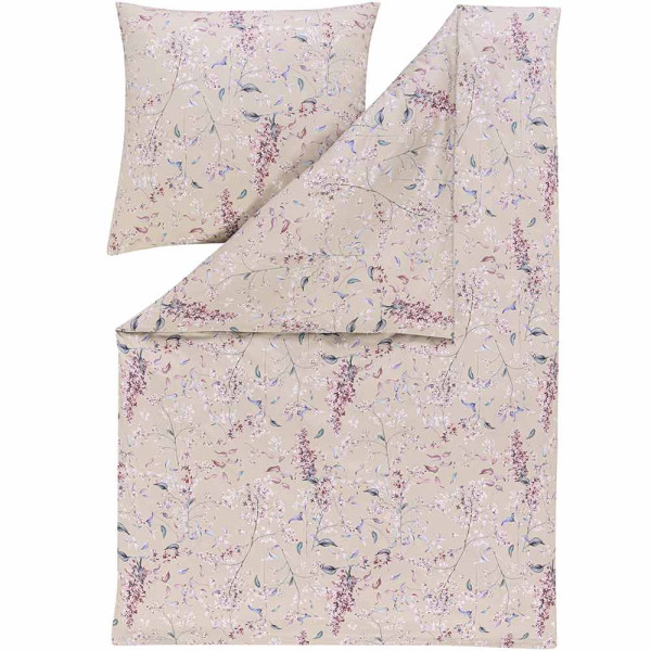 Beige Bettwäsche im floralen Design mit Blütenmustern. Die Bettdecke ist im Hintergrund sichtbar, während das Kissen im Vordergrund liegt. Ideal für eine dekorative Schlafzimmergestaltung.