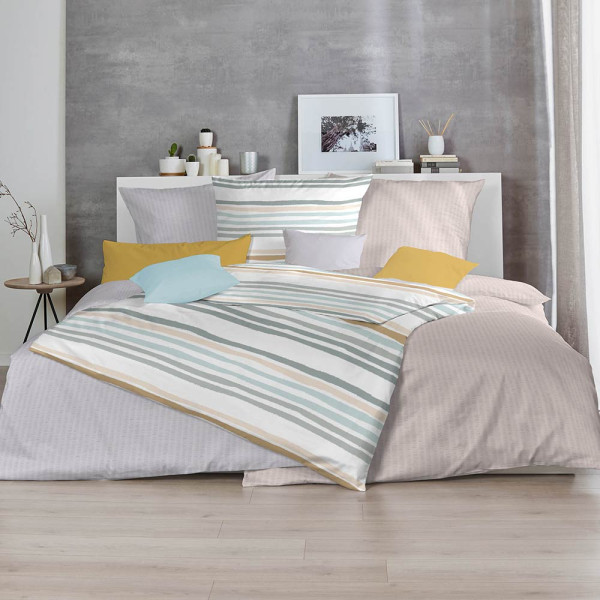 Weiche Bettwäsche in Taupe im Soft Seersucker-Stil liegt auf einem Bett. Der Kissenbezug ist ebenfalls in Taupe und zeigt eine leichte Struktur.