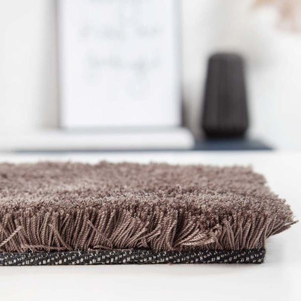 Dunkelbrauner webteppich aus Polyester liegt sichtbar auf einem weißen Hintergrund. Die Oberfläche ist weich und wirkt gleichmäßig strukturiert. Der Teppich eignet sich für individuelle Maßanfertigungen.