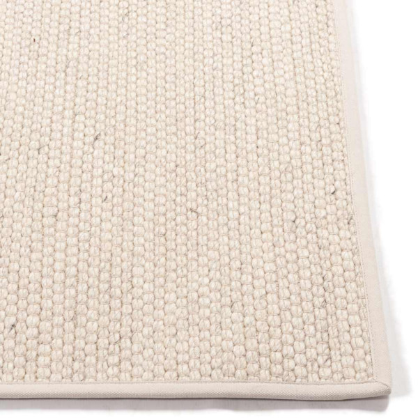 Hellbeige Teppich nach Maß mit feiner Struktur steht bereit. Er zeigt eine Baumwoll-Einfassung und eignet sich ideal für verschiedene Wohnräume. Qualität und Anpassungsmöglichkeiten sind betont.