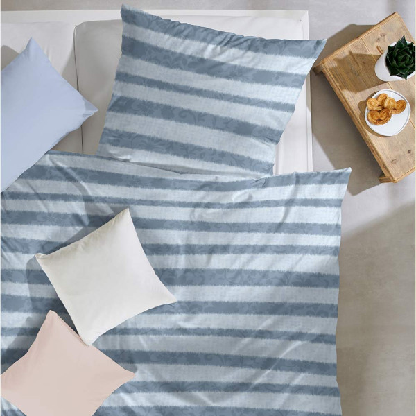 Blaue Feinbiber-Bettwäsche mit grauen Streifen, bestehend aus einer Decke und einem Kissen, sorgfältig auf einem weißen Untergrund drapiert.