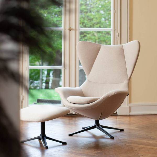 Beige Relaxsessel Stilo steht auf einem schmalen Metallfuß. Die geschwungene Form bietet Komfort und elegantes Design für Wohnzimmer oder Büros. Erhältlich für 1.119,00 €.