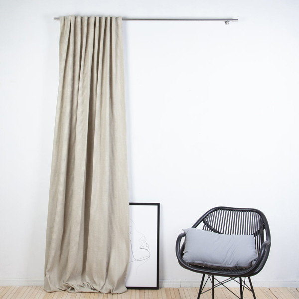 Unifarbener Fertigschal in Beige hängt an einem silbernen Vorhangstangenhalter. Der Stoff hat eine gerippte Struktur, wodurch er eine elegante Optik erhält.