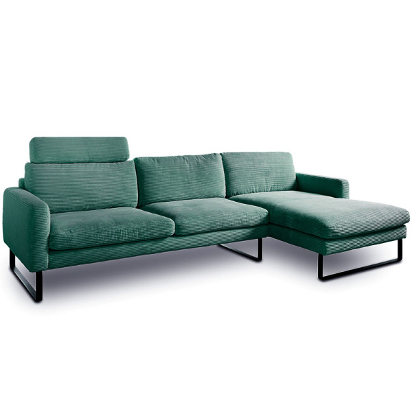 Grünes Cordsofa Ricadi mit länglicher Sitzfläche und einer integrierten Ottomane steht auf einem schwarzen Metallgestell. Es bietet modernen Komfort und Stil für Wohnräume.