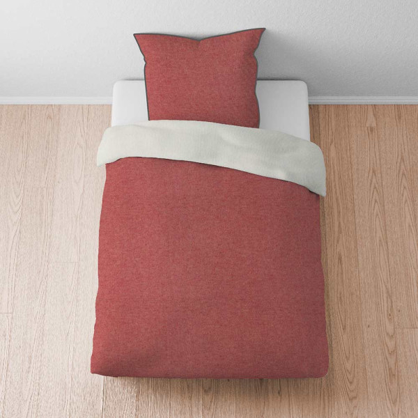 Rote Flanellbettwäsche von Biberna liegt gefaltet auf einer Oberfläche. Sie besteht aus zwei Teilen: einem Bettbezug und einem Kopfkissenbezug. Der Bettbezug ist umgeschlagen.