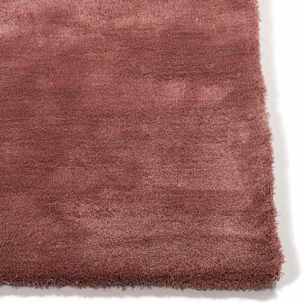 Weicher, rosafarbener Teppich aus Polyester liegt auf einem hellen Untergrund. Die Oberfläche ist kurzflorig und einladend. Der Teppich eignet sich für individuelle Gestaltung in verschiedenen Größen.