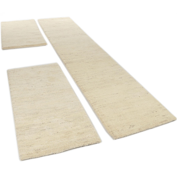 Drei Teppichstücke in hellbeige, zwei rechteckige (70x140 cm) und eines längliches (70x340 cm), sind nebeneinander angeordnet. Sie sind für die Bettumrandung gedacht.