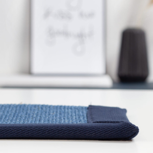 Blauer Sisal-Teppich mit strukturiertem Gewebe und schmalem, dunkelblauem Rand. Der Teppich wurde professionell nach Maß gefertigt und eignet sich für individuelle Gestaltung.