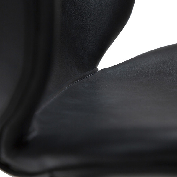 Moderner schwarzer Stuhl aus Kunstleder steht auf drei schlanken Beinen. Die Rückenlehne ist rundlich und harmoniert mit der abgerundeten Sitzfläche.