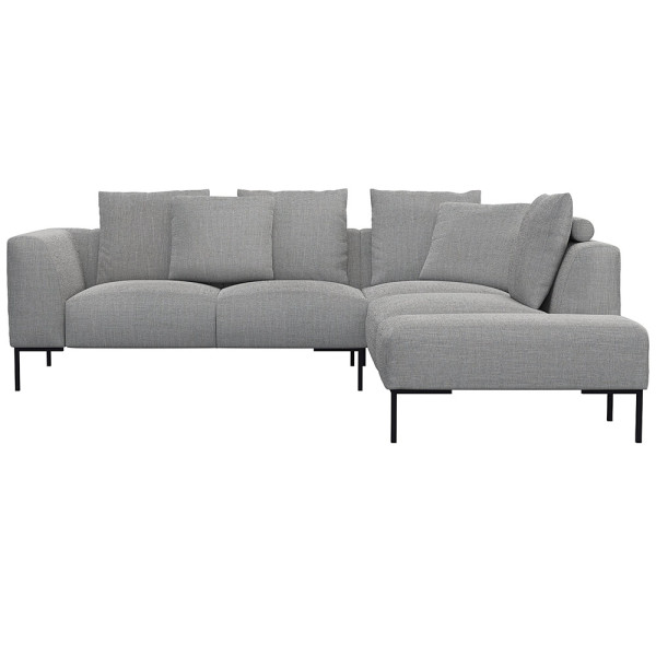 Helles, modernes Ecksofa SAVA mit offenem Ende. Das Sofa besitzt mehrere bequeme Kissen und steht auf schwarzen Metallbeinen. Es eignet sich ideal für stilvolle Wohnräume.