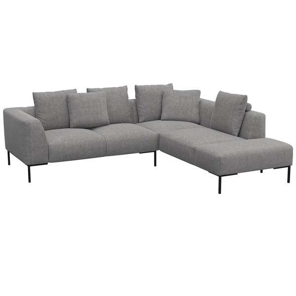 Helles, modernes Ecksofa SAVA mit offenem Ende. Das Sofa besitzt mehrere bequeme Kissen und steht auf schwarzen Metallbeinen. Es eignet sich ideal für stilvolle Wohnräume.